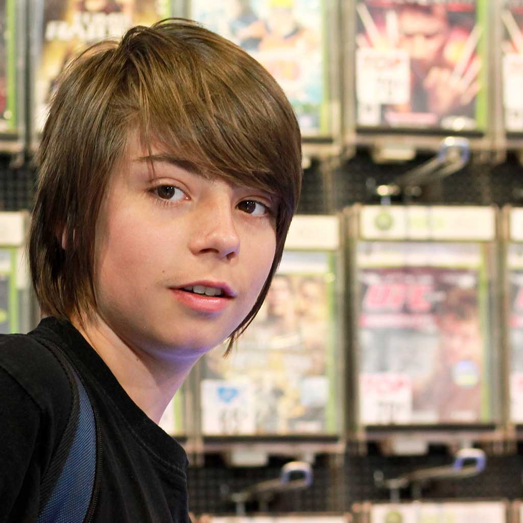 boy-standing-infront-of-video-games boy-standing-infront-of-video-games